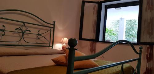 a bedroom with a bed and a large window at Le Caracol - Appartamenti immersi nel verde della campagna e a 1 chilometro da Orosei in Orosei