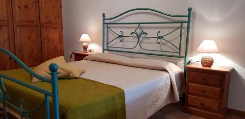 a bedroom with a large bed and two night stands at Le Caracol - Appartamenti immersi nel verde della campagna e a 1 chilometro da Orosei in Orosei