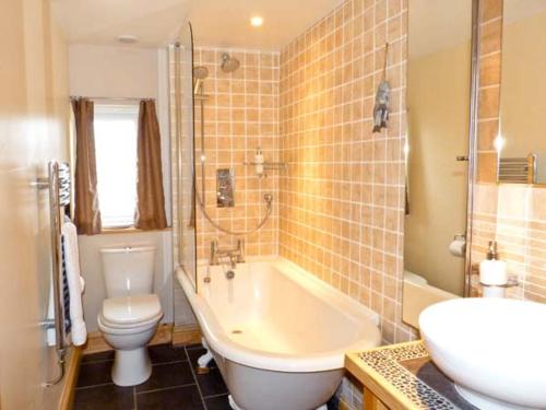 a bathroom with a tub and a toilet and a sink at 3 Apsley Cottages in Chartham