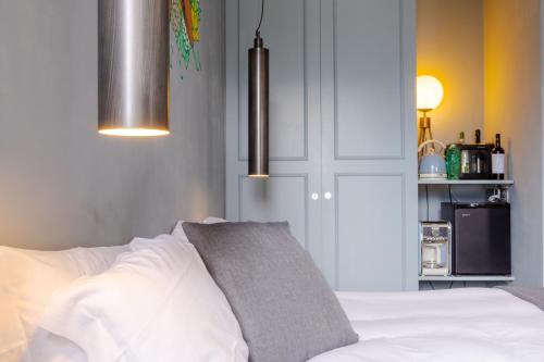 a bedroom with a white bed with a gray pillow at Bello!Lake Como Suites in Como