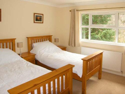 a bedroom with two beds and a window at Forestry Cottage in Pale