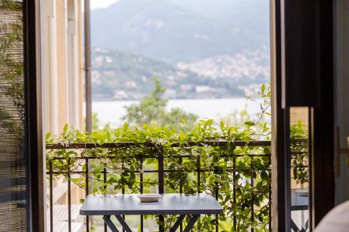 a table on a balcony with a view of the water at Bello!Lake Como Suites in Como