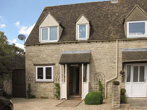 a large brick house with a white door at Hour Cottage in Stow on the Wold