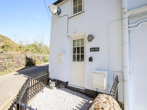 a white house with a white door on a street at Bryn Coed in Porthmadog