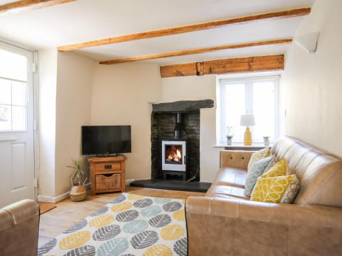 a living room with a couch and a fireplace at Bryn Coed in Porthmadog