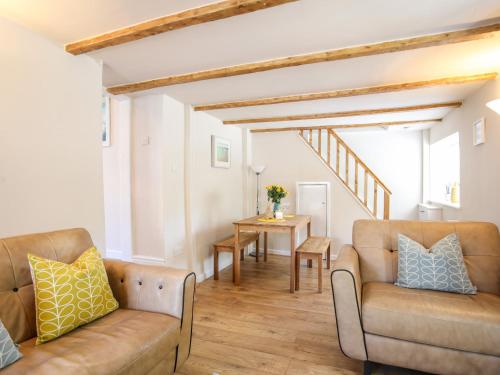 a living room with two couches and a table at Bryn Coed in Porthmadog
