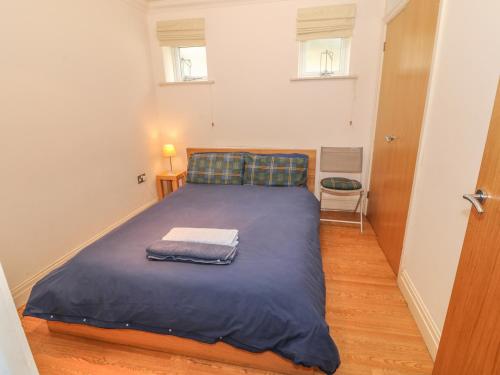 een slaapkamer met een bed met een blauwe deken bij Tywod a Mor in Morfa Nefyn