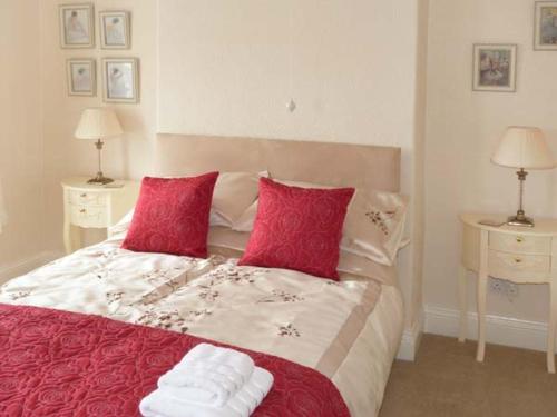 a bedroom with a large bed with red pillows at Elizabeth House in Hornsea