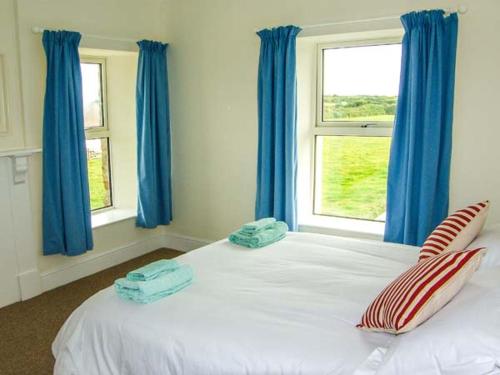 Walton WestにあるThe Grangeのベッドルーム(青いカーテン付きの白い大型ベッド1台付)