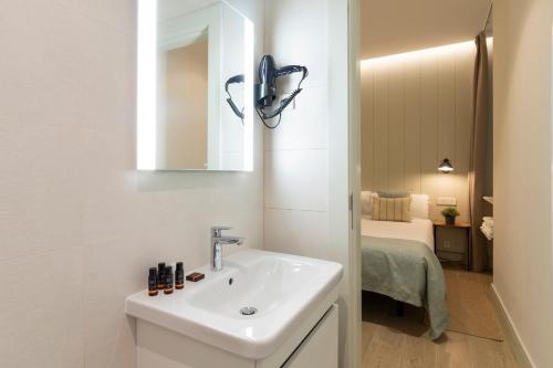 baño con lavabo, espejo y cama en Prado Rooms 46 - Darya Living, en Madrid