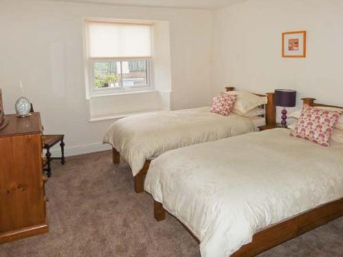 HolkerにあるOuterthwaite Cottageのベッドルーム1室(ベッド2台、窓付)
