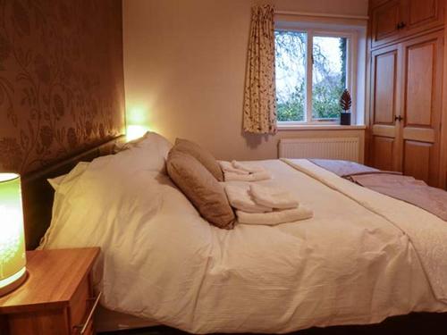 Un dormitorio con una cama blanca con toallas. en Bridleway Cottage, en Wennington