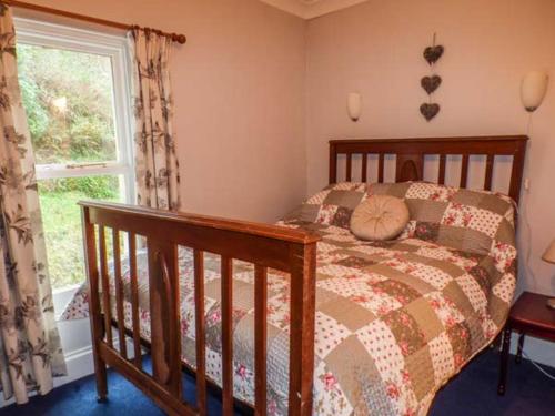 a bedroom with a bed and a window at Teifi House in Cilgerran