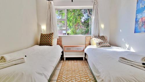 two beds in a small room with a window at Seaglen Dunes Resort in Port Edward