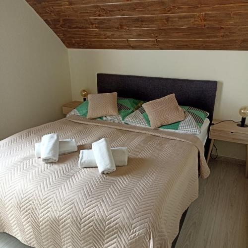 a bedroom with a large bed with towels on it at Ubytovanie Home Katka in Bešeňová