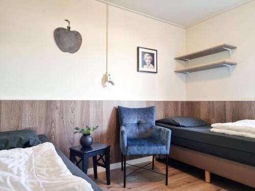 1 dormitorio con 1 cama, 1 silla y reloj de manzana en Vakantiehuis de Strandloper Serooskerke Se08, en Serooskerke