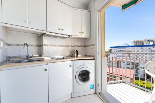 a kitchen with a washing machine and a balcony at Sunny Seaside Studio in Arroyo de la Miel
