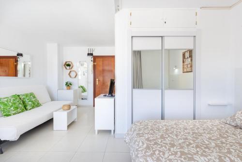 a white living room with a bed and a couch at Sunny Seaside Studio in Arroyo de la Miel