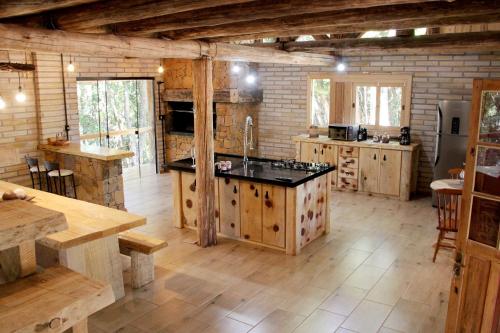 a large kitchen with wooden cabinets and a counter top at Chalé Refúgio Panorâmico in Canela