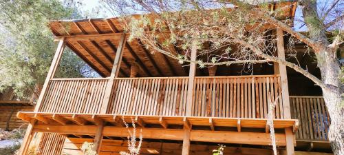 a large wooden tree house with a deck at Villa Occitana in Calvisson