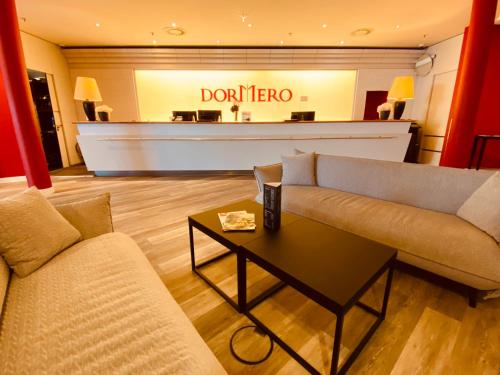 a living room with a couch and a table in a store at DORMERO Hotel Dresden City in Dresden