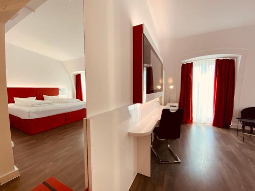 a hotel room with a bed and a desk and a bedroom at DORMERO Hotel Dresden City in Dresden