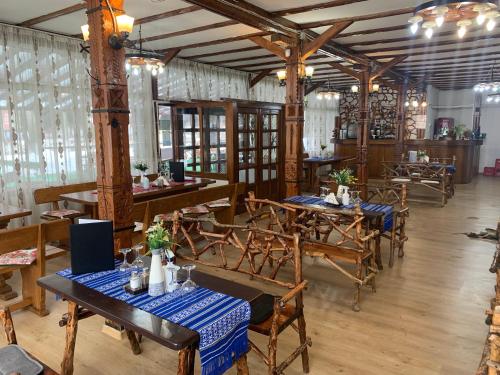un ristorante con tavoli e sedie in legno con tovaglie blu di Vila Azuga ad Azuga