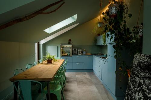 una cucina con tavolo in legno e armadi blu di Bello!Lake Como Suites a Como