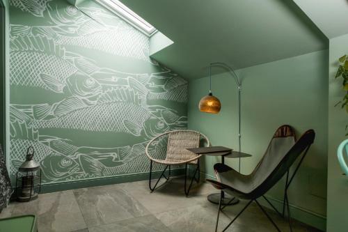 a dining room with a green wall with a table and chairs at Bello!Lake Como Suites in Como