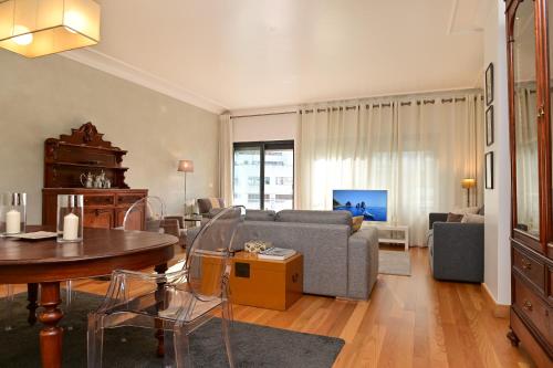 a living room with a couch and a table at Columbano Garden, Family Apartment in Lisbon