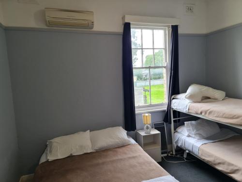 a bedroom with two bunk beds and a window at Kearsley Hotel in Cessnock
