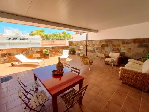 ein Wohnzimmer mit einem Tisch und Stühlen sowie einem großen Fenster in der Unterkunft Alma Canaria Apartments & Rooms in Las Palmas de Gran Canaria