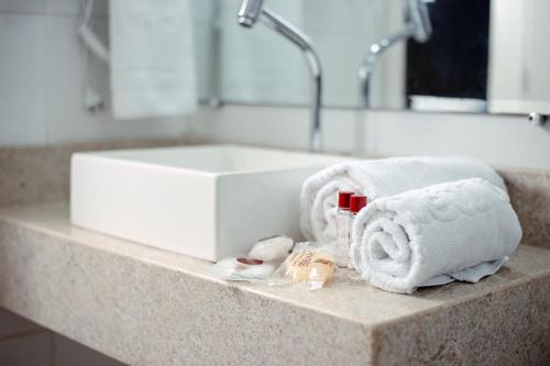 a bathroom counter with towels and a sink at San Marino Hotel in Paulo Afonso