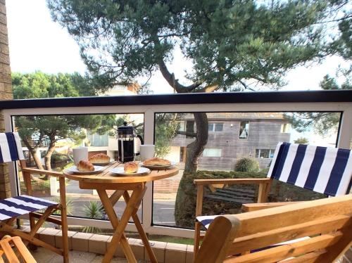 een tafel met eten op een patio bij Top Floor Sandbanks Apartment with Free Parking just minutes from the Beach and Bars in Canford Cliffs