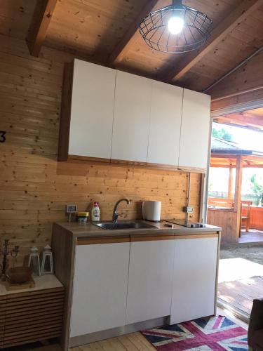 a kitchen with white cabinets and a sink at Vila Gjiri Lalzit in Durrës