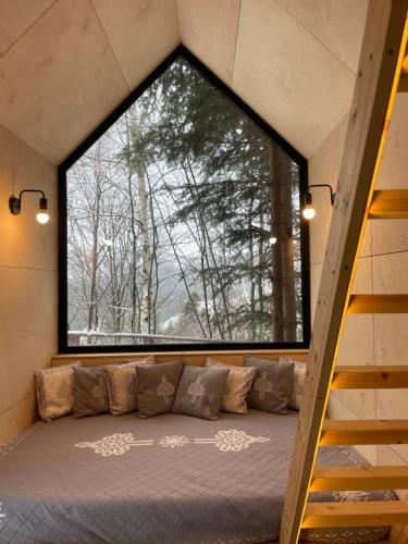 Domek na drzewie Ceprowo في شتوروك: نافذة كبيرة في غرفة مع أريكة في الأمام