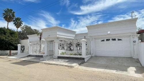 a white house with a gate and a driveway at Brenda alicia in Puerto Peñasco