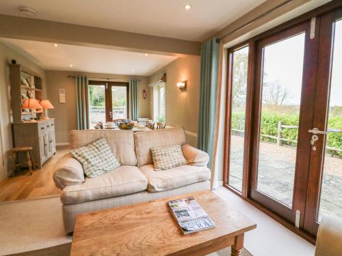 a living room with a couch and a table at Long Meadow in Heyshott