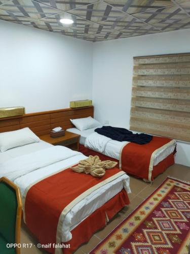 a room with three beds in a room at Ameer apartment in Wadi Musa