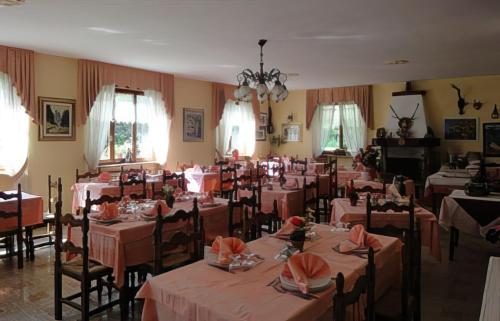 a dining room with tables and chairs with pink tablecloths at Hotel Laurent in Gaby