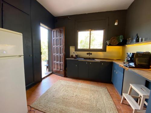 a kitchen with blue cabinets and a white refrigerator at Charming apartment in a duplex with garden & balcony in Cunit