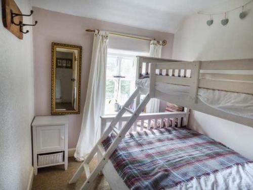 a bedroom with a bunk bed and a mirror at River Cottage in Bakewell