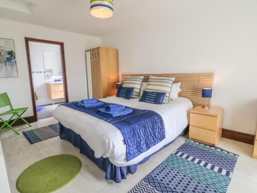 ホリーヘッドにあるSeascapeのベッドルーム1室(大型ベッド1台、青いシーツ、枕付)