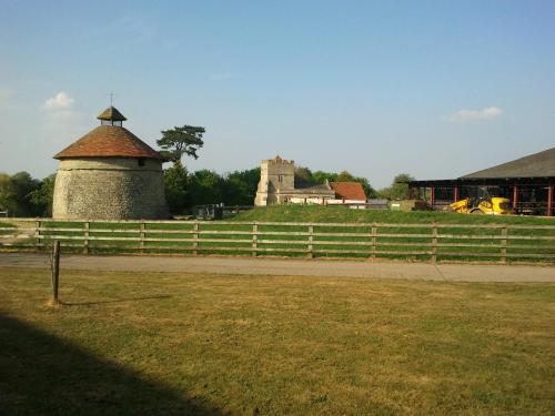 a fence in front of a farm with a building at Furtho Manor Farm in Milton Keynes