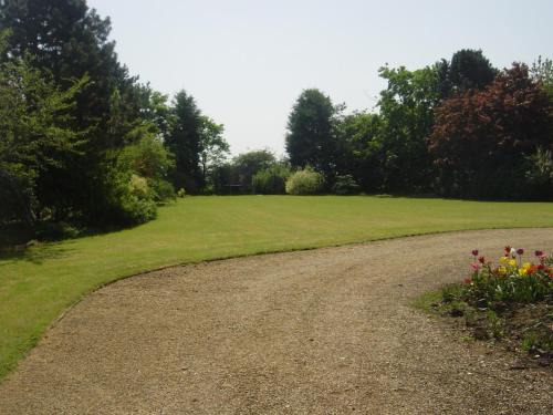 a gravel road leading to a field with flowers at Furtho Manor Farm in Milton Keynes