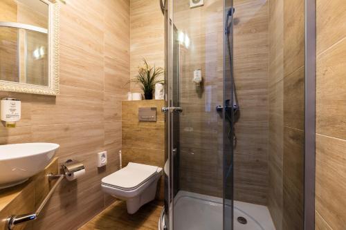 a bathroom with a toilet and a shower stall at Hotel Diamond w Białym Dworku in Rumia