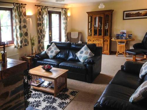 a living room with a couch and a table at Llety'r Bugail in Dolgellau