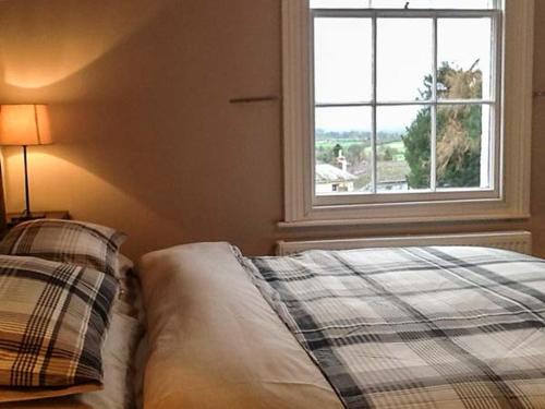 a bedroom with a bed and a window at Woodland Cottage in Malvern Wells