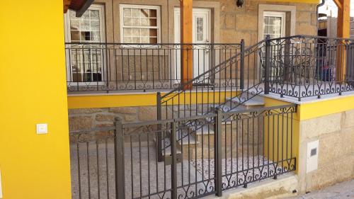 a yellow building with a wrought iron stairway at Cantinho da Estrela in Seia