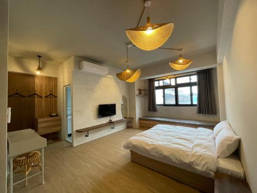 a bedroom with a bed and a television and lights at Lily's House in Zhushan